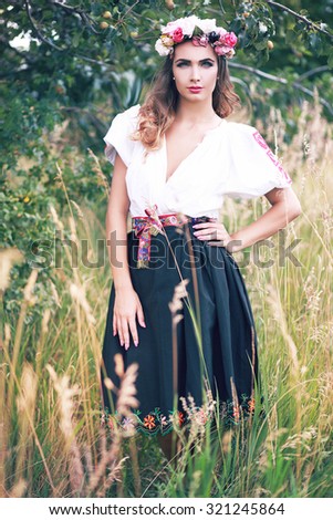 beautiful female model in slovakian national costume posing outdoor in flower head crown