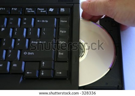 hand pushing in CD tray on notebook computer