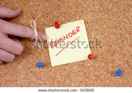 hand with string tied on finger pointing at reminder note pinned on corkboard