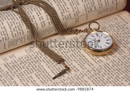 old gold pocket watch on antique bible book