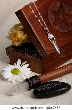 close up of wiccan objects - tarot cards box wand goddess pendant wisdom stone