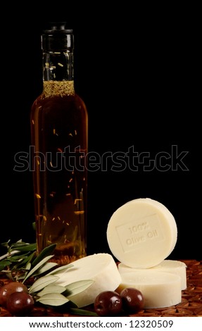 natural olive oil soap olives branch and bottle against wooden mat