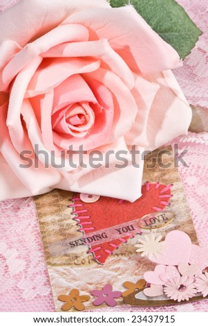 close up of \'sending you love\' message with pink hearts and rose in foreground and background