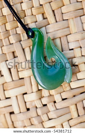 close up of carved maori nephrite jade / greenstone pendant on woven kite bag