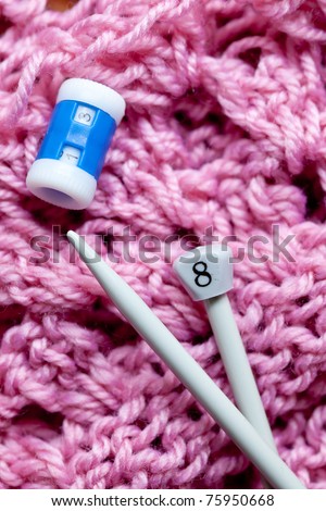 closeup of knitting with metal needles and pink wool