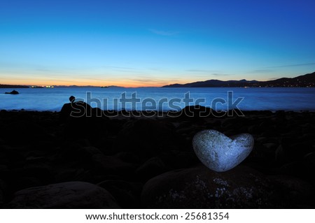 Balanced heart shaped stone on beach