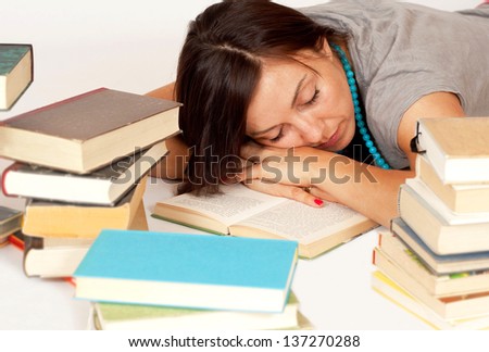 A darkhaired Bookworm sleeps over her books
