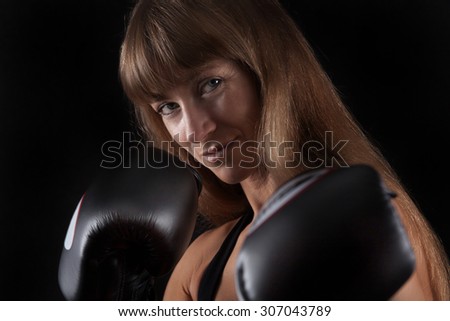 Fitness women  boxing gloves is looking very straight in the camera.