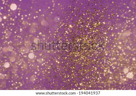 golden glitter background on purple fabric structure lines, with pararell fading, layered real bokeh particles in tilt shift