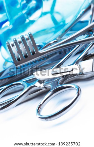 close up of selection of metal surgical equipment on blue and white background