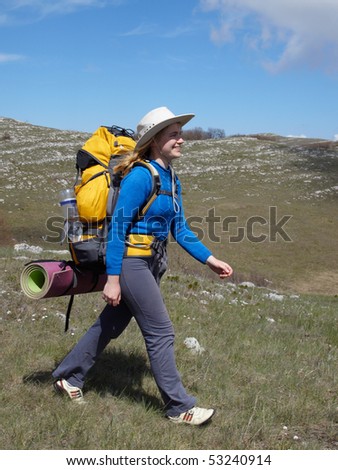 Happy gir in hatl with yellow backpack walking into the distance Stok fotoğraf © 
