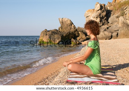 girl practice yoga pose padmasana on the sea coast