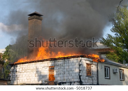 house on fire and clouds of black smoke