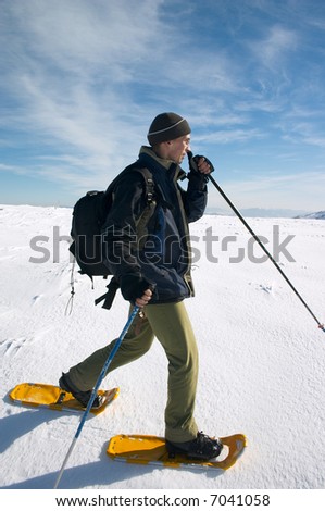 tourist in snow-shoes traveling in winter mountains