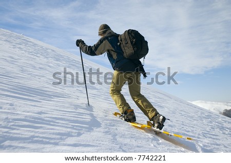 backpacking tourist climbing on winter mountain
