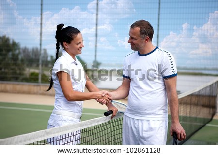 Couple handshaking at the tennis court after a match