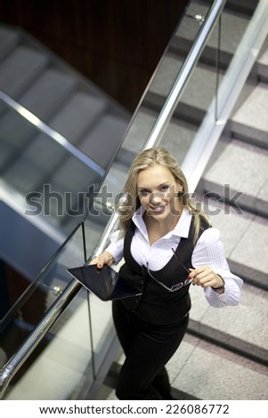 A pretty business woman walking down the stairs