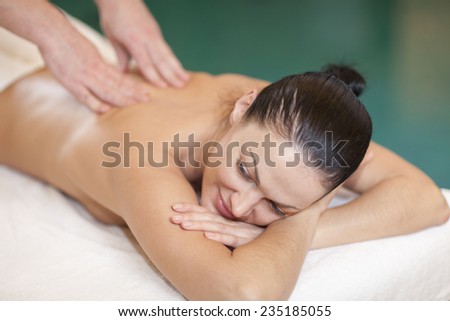 health, beauty, resort and relaxation concept - beautiful woman in spa salon getting massage