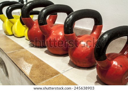 Different sizes of kettlebells weights lying on gym floor