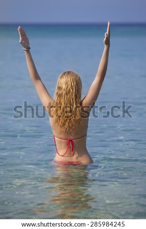 woman spreading her arms on beach in sea