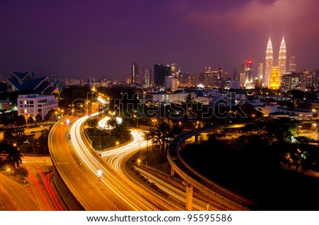 Kuala Lumpur twin towers with stunning light trail from the busy highway traffic.