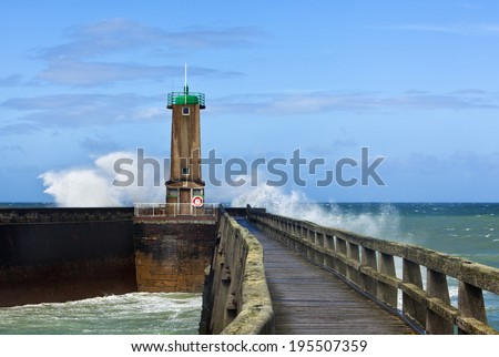 North Sea waves breaking at a lighthouse of the port entrance of Fecamp, Normandy