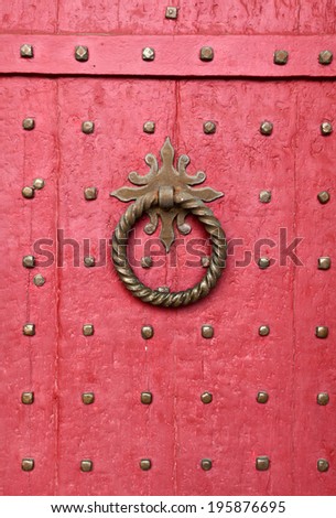 Doorknocker on red entrance door of Winchester Cathedral, England