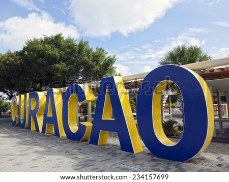 Word Curacao written in blue and yellow painted concrete letters at Queen Wilhelmina Park, Willemstad, Curacao