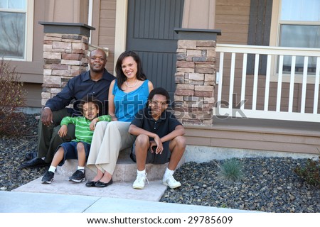 African American family sitting together on front steps of home