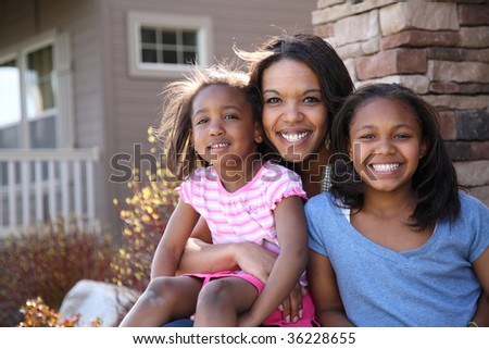 Portrait of mother and daughters sitting on porch