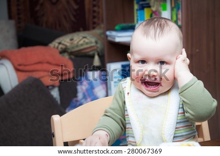 Funny baby with mouth stained with blueberry jam