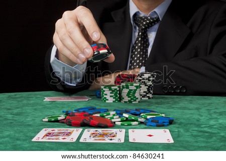 A businessman placing a bet in a Texas hold \'em poker game.