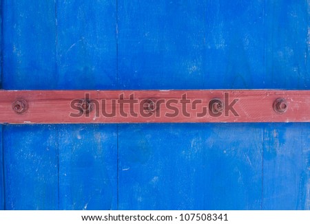 Weathered blue wooden door texture with rusty forged nail heads