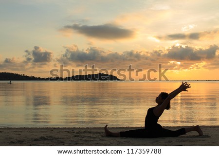 Silhouette of a beautiful yoga girl at sunrise on the beach,,Hanumanasana,Monkey Pose