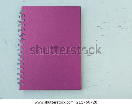 Purple notebook paper  on wood background