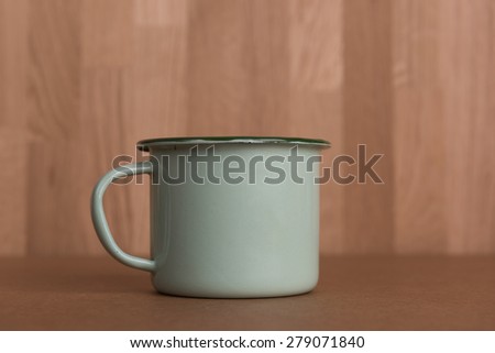 Vintage green mug on wood board background