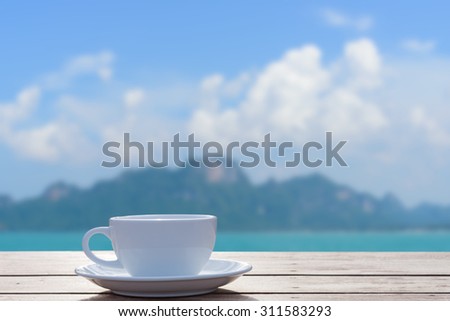 Morning coffee cup with beautiful seascape and white birds background