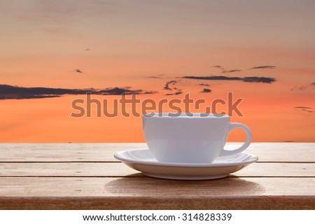 Morning coffee cup with skyscape sunrise background
