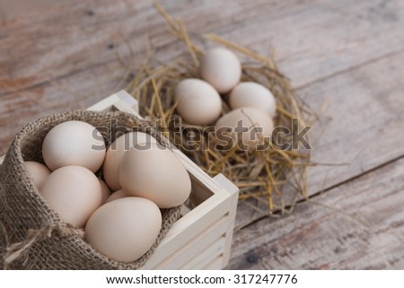 Home grown organic eggs in wooden basket on grunge board,still life
