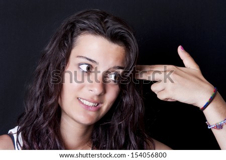 Bored teenage girl making gun with her hand pretending to blow up her head