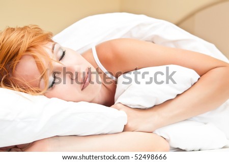 Beautiful young sleeping woman seeing sweet dreams
