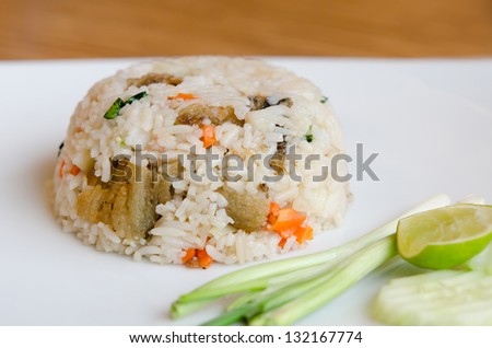Mixed cooked rice with fried fish , sauce and  vegetable on white dish