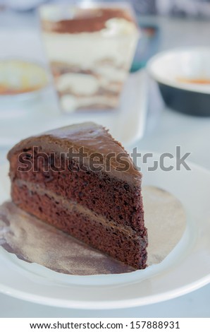 close up slice of chocolate fudge cake on white dish