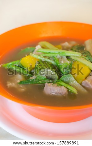 close up savoury thick soup made from pork , spices and mix vegetable in orange  bowl