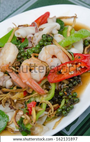 top view  stir fried prawn and squid  with mix  vegetable on dish , spicy dish