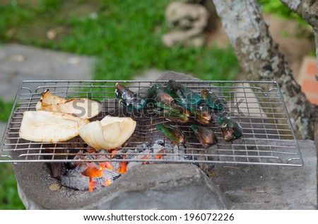 Grilled squid and green mussel on the grill , seafood bbq