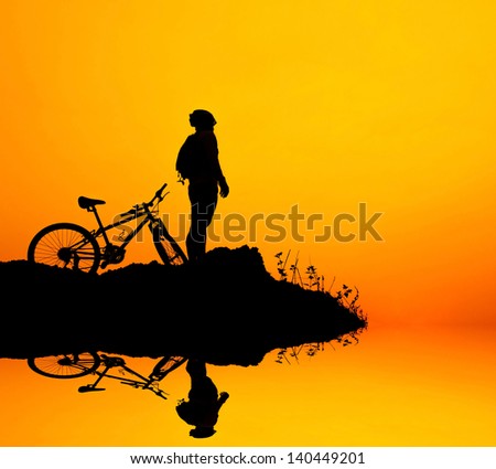 Man and bike silhouette with the sky as background.