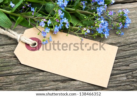 blue flowers and label on wooden ground/blue flowers/spring