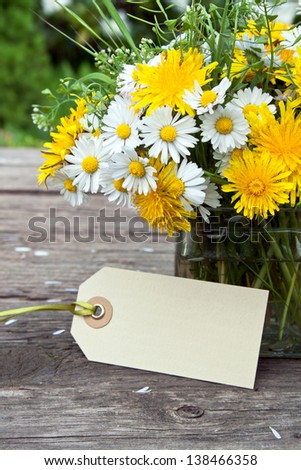 wild flowers and label on wooden ground/wild flowers/spring