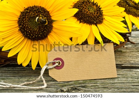 sunflowers and label on wooden table/sunflower/summer